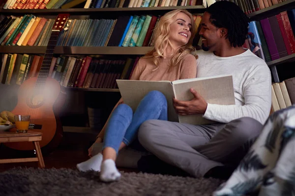 Sorrindo casal lendo um livro juntos.Apreciando a leitura em casa — Fotografia de Stock