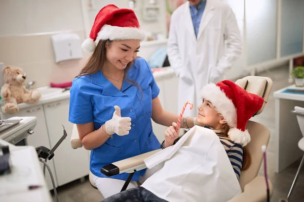 Mujer dentista en Santa Sombrero examinando paciente dental en ambulante . — Foto de Stock