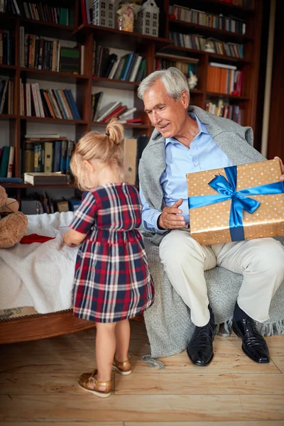 Abuelo con regalos pasar la Navidad junto con su nieta — Foto de Stock