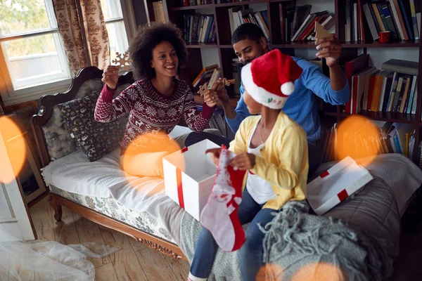 Happy Afro-American family opening Christmas presents