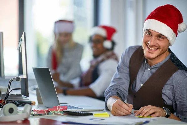 Lavoro a Natale. Giovane in cappello di Babbo Natale lavoro in ufficio — Foto Stock