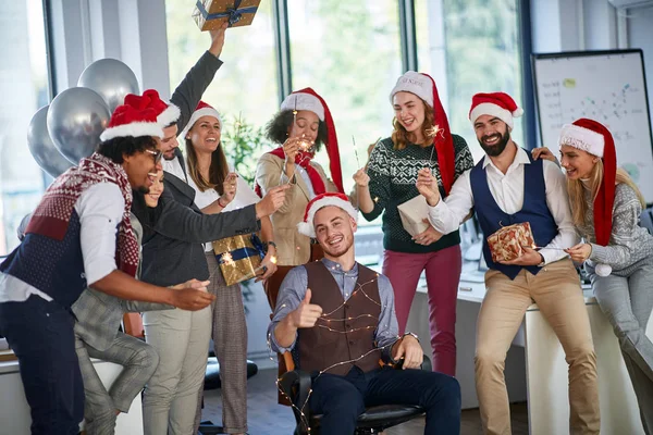 Vacanze invernali al lavoro. Gruppo di giovani imprenditori che festeggiano il Natale — Foto Stock