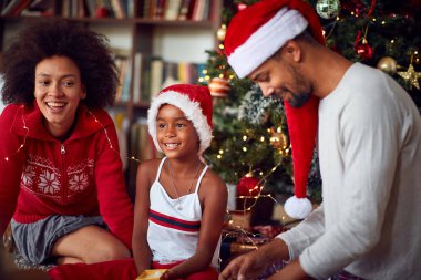 Küçük kızı olan bir aile Noel 'de birlikte oynuyorlar.