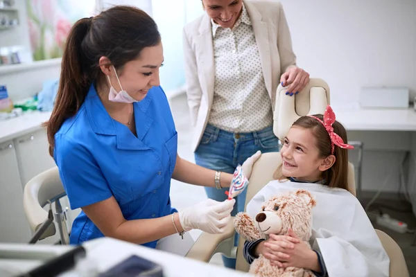 Девочка-ребенок и стоматолог проверяют зубы на стоматологической процедуре — стоковое фото