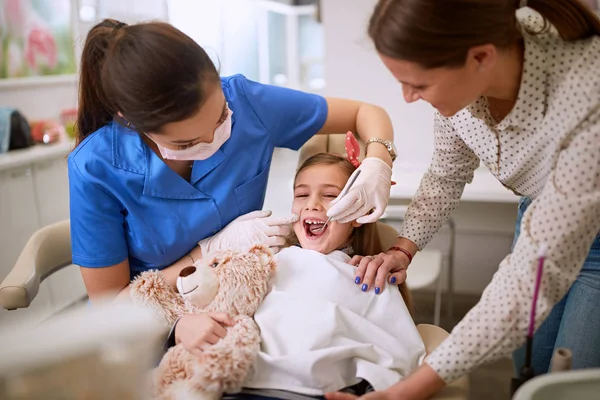 Zahnarzt untersucht Zähne von Mädchen. — Stockfoto