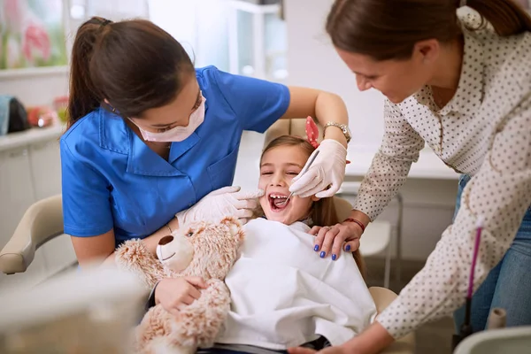 Dentista revisando los dientes de las chicas . — Foto de Stock