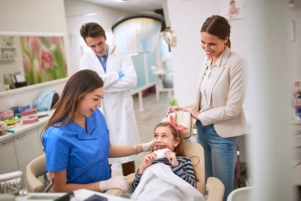 Девушка в стоматологическом кресле ест шоколад — стоковое фото