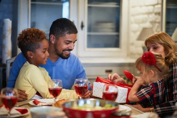 Family opening Christmas presents at table — Stock Photo, Image
