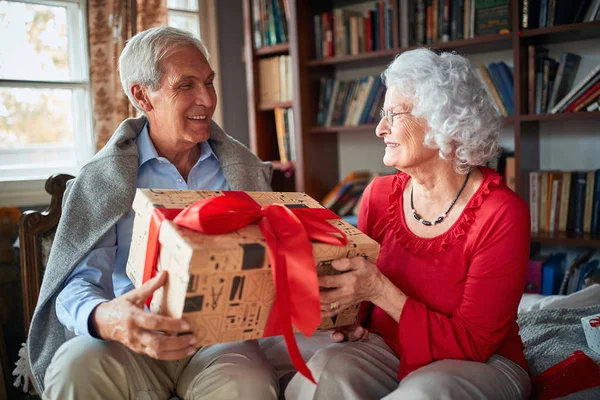 Pareja mayor intercambiando regalos de Navidad —  Fotos de Stock