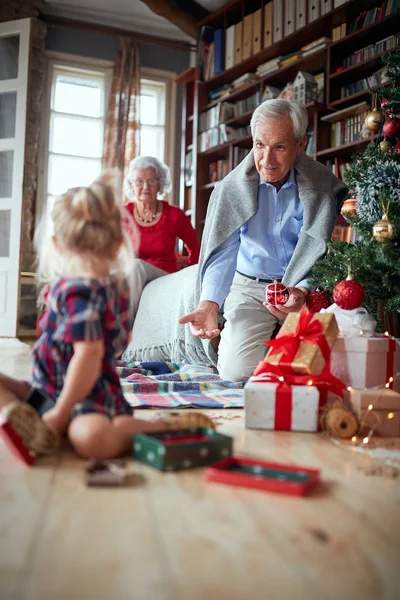 Παππούς κρατώντας ένα χριστουγεννιάτικο δέντρο διακόσμηση — Φωτογραφία Αρχείου