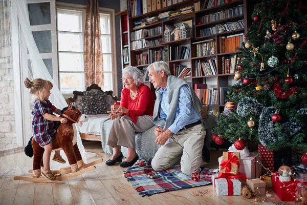 Abuelos con su nieta al lado del árbol de Navidad — Foto de Stock