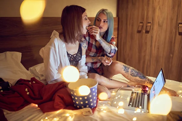 Le donne tatuate mangiano popcorn e si godono a casa  . — Foto Stock