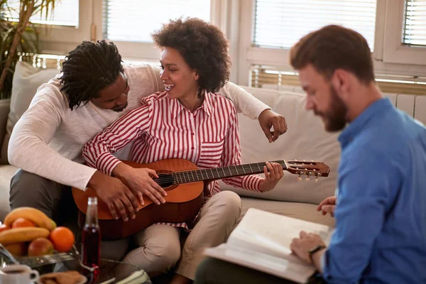 Female with male playing guitar — Stockfoto