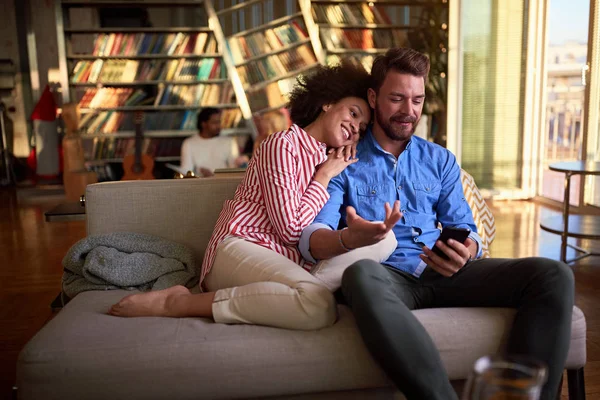 Paar in liefde indoor op zoek in mobiele telefoon — Stockfoto