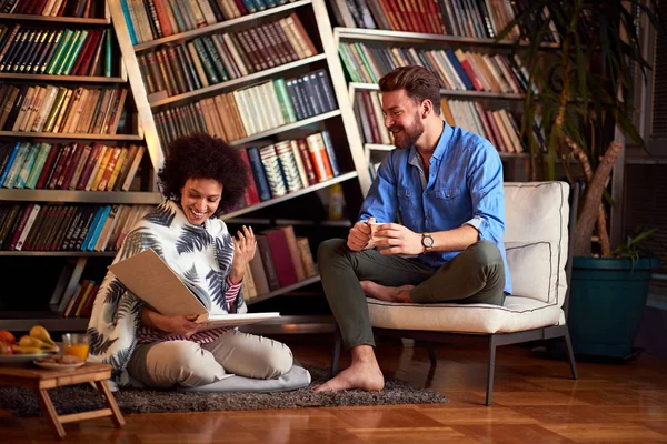 Par som har kul inomhus med bok och kaffe — Stockfoto