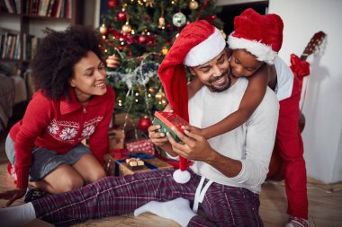 Noel 'i birlikte kutlayan aile. Baba ve kızı Noel hediyesini açtılar.