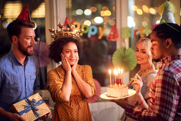 Здивована дівчина на день народження дивиться на торт на день народження — стокове фото