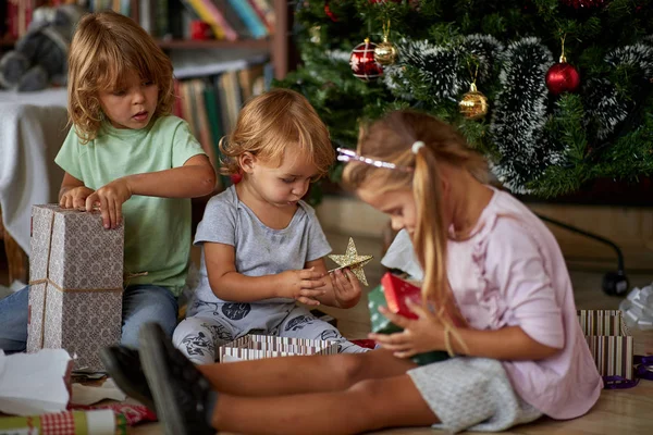 Öppna gåvor På juldagsmorgonen. Barn öppnar julklapp — Stockfoto