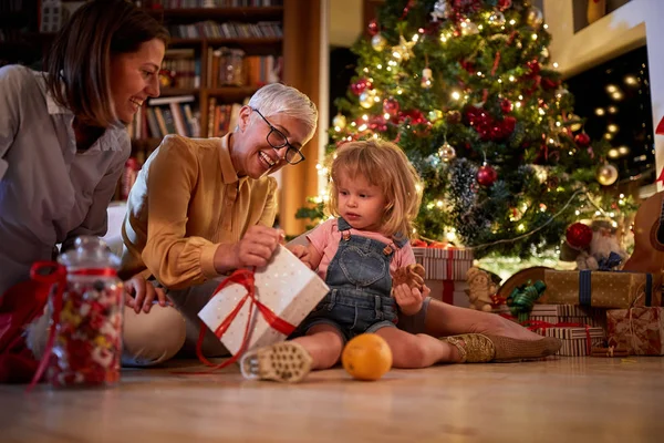 Vrolijke oma met haar kleindochters vieren kerstmis — Stockfoto