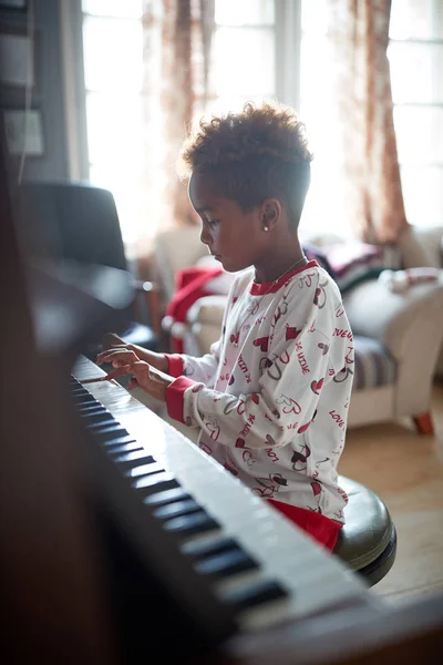 Girl play music at piano on Christmas Day. — Stock Photo, Image