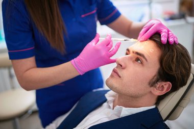 Male having aestetic intervention on his forhend