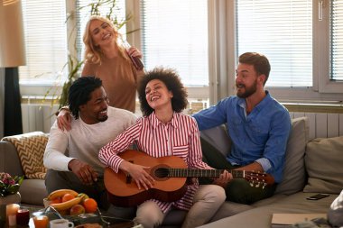 Neşeli arkadaşlar gitarla eğleniyorlar.