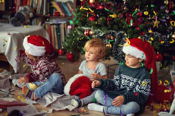 Niños jugando por árbol en la mañana de Navidad — Foto de Stock