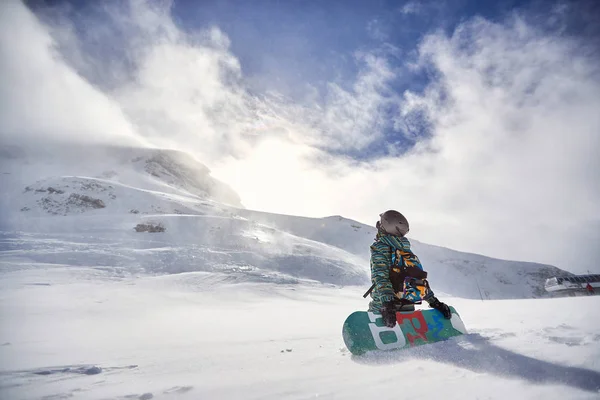 Día nevado en las montañas de invierno. Snowboarder con snowboard — Foto de Stock