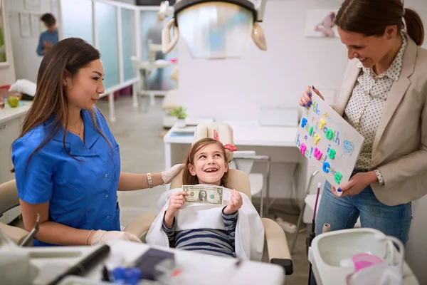 Chica en la bodega dentista sacó diente y dólar — Foto de Stock