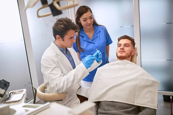 Homem no dentista na cadeira dentária — Fotografia de Stock