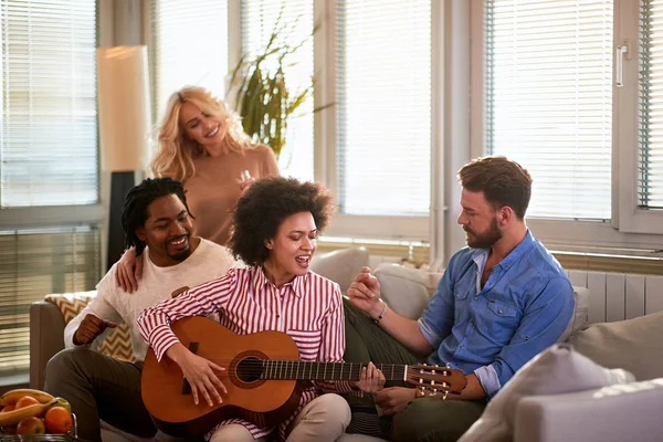Vrouw met vrienden die gitaar spelen — Stockfoto