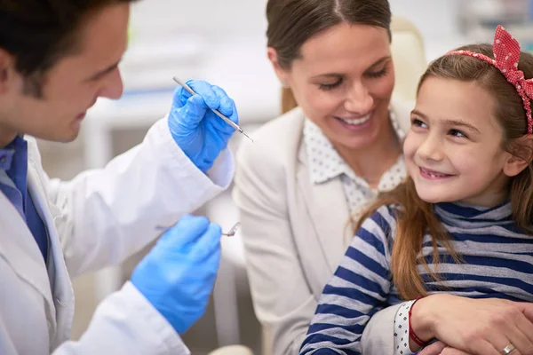 Vårdande mor uppmuntra sin dotter för en tandundersökning — Stockfoto