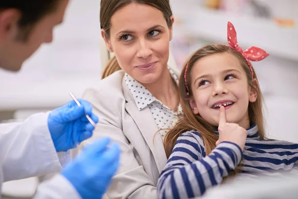 Mamá y dentista tratando de convencer a la dulce niña para hacer una guarida — Foto de Stock