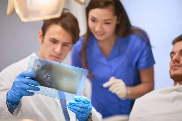 Dentista olhando para um raio-x — Fotografia de Stock