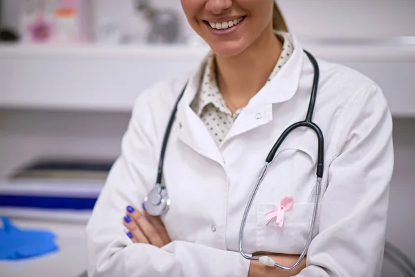 Doutor vestindo sinal de consciência de câncer de mama — Fotografia de Stock