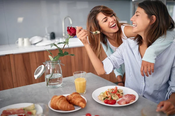 Sorrindo gay lasbian casal no manhã no cozinha comer pequeno-almoço — Fotografia de Stock