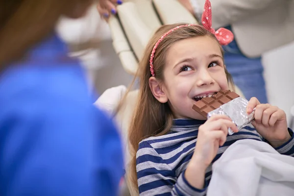 Jutalom a rossz fogakért, gyerek csokit eszik. — Stock Fotó