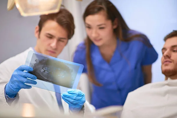 Dentista e sua enfermeira perguntando sobre um raio-x — Fotografia de Stock