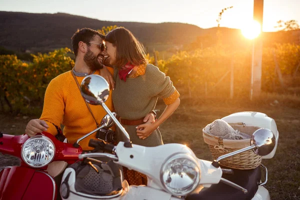 Girl and men riding motorcycle on road at sunset on vacation — Stock Photo, Image
