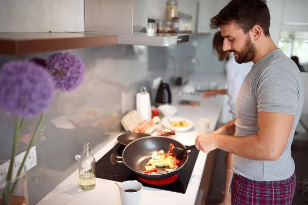 Mann im Pyjama bereitet Frühstück für sein Mädchen zu. — Stockfoto