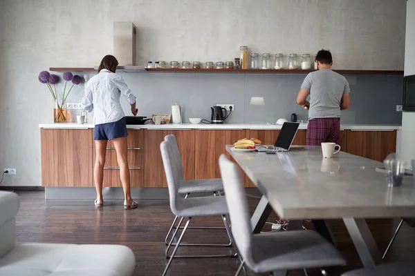 Junges Paar bereitet morgens in der Küche das Frühstück zu — Stockfoto