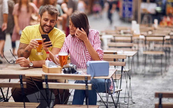 Couple of tourists checking location on phone at caffe. — Stock Photo, Image