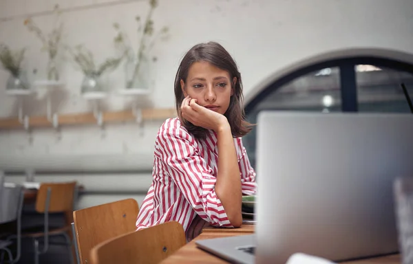 Mujer sentada en la cafetería y trabajando en el portátil —  Fotos de Stock