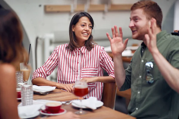 Unga människor slappnar av i caféet kommunicera — Stockfoto