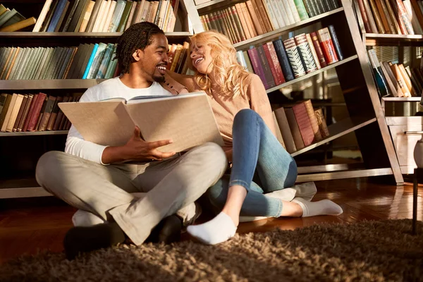 Man och kvinna i biblioteket njuter — Stockfoto