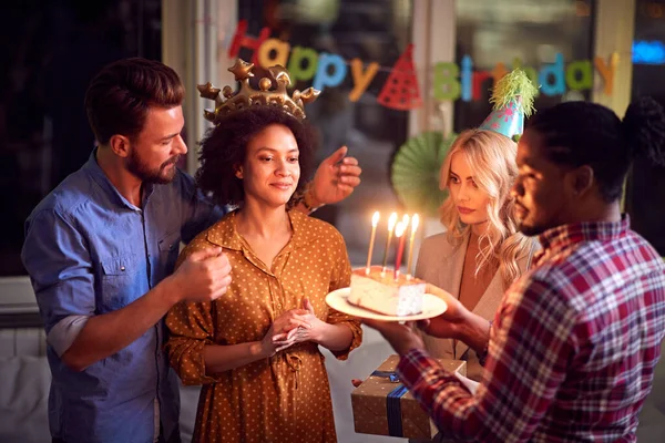 Friends giving birthday cake to birtday girl — Stock Photo, Image