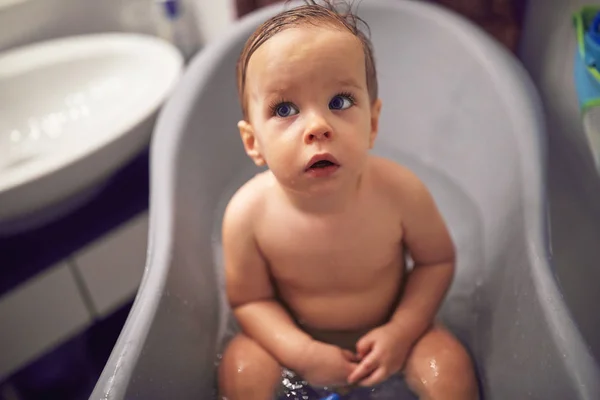 Happy baby taking a bath playing . Little child in a bathtub. Sm — 스톡 사진