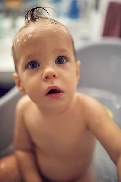 Silly baby taking a bath playing with foam bubbles. Little child — Stock Photo, Image