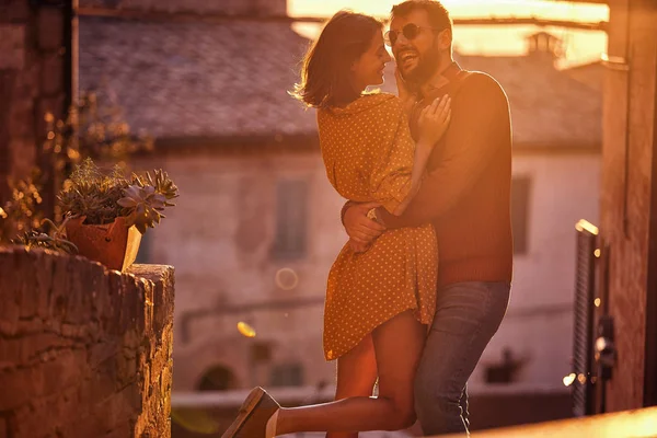 Uśmiechnięty mężczyzna i kobieta korzystających na romantyczny zachód słońca. — Zdjęcie stockowe