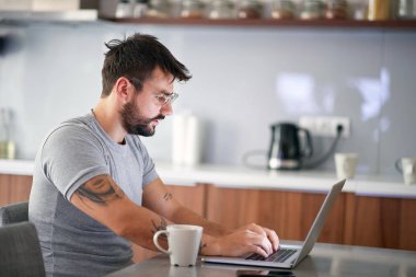  Adam sabahları dizüstü bilgisayardaki e-postaları kontrol ediyor.